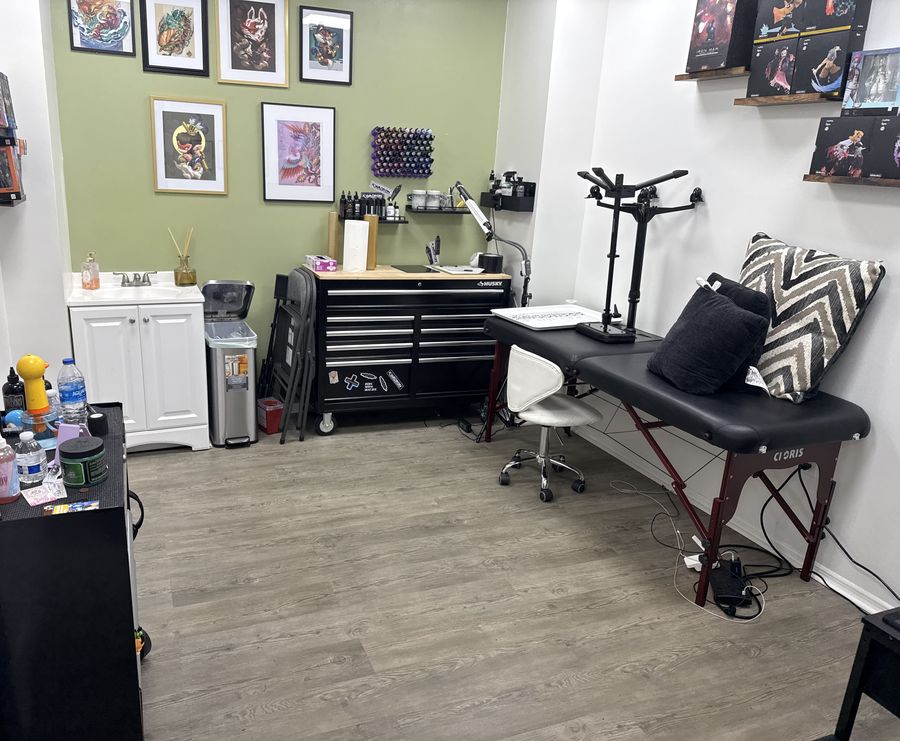 Private tattoo studio in Orlando with a single tattoo bed, ink station and anime artwork on the walls